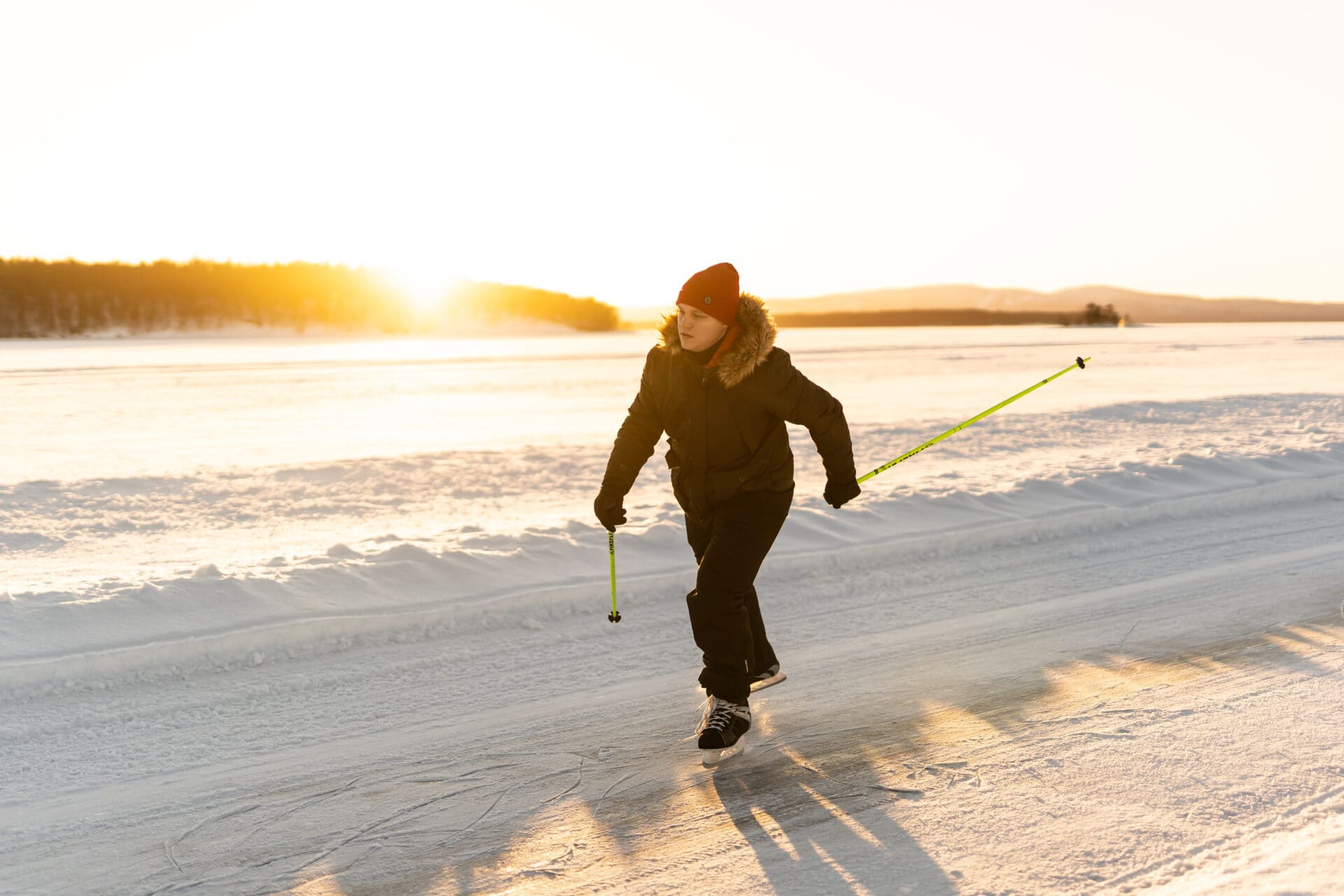 Retkiluistelija luistelemassa Pielisen jäällä aurinkoisena päivänä.